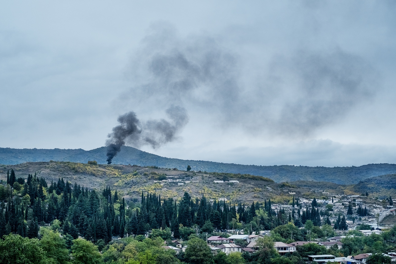 SOTTO ASSEDIO. Stepanakert (Repubblica dell' Artsakh), 7 ottobre 2020 - Una colonna di fumo si leva dai sobborghi di Stepanakert dopo un raid aereo. Per 44 giorni la città è stata bombardata notte e giorno dall'Azerbaijan con il supporto militare dalla Turchia. L'offensiva, iniziata il 27 settembre 2020, è terminata il 9 novembre 2020 con il cessate il fuoco mediato dalla Russia. Da allora l'Azerbaijan ha ripetutamente violato l'accordo